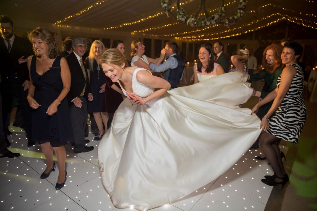 guests lift brides train marquee reception blenheim palace venue woodstock oxfordshire wedding photographers